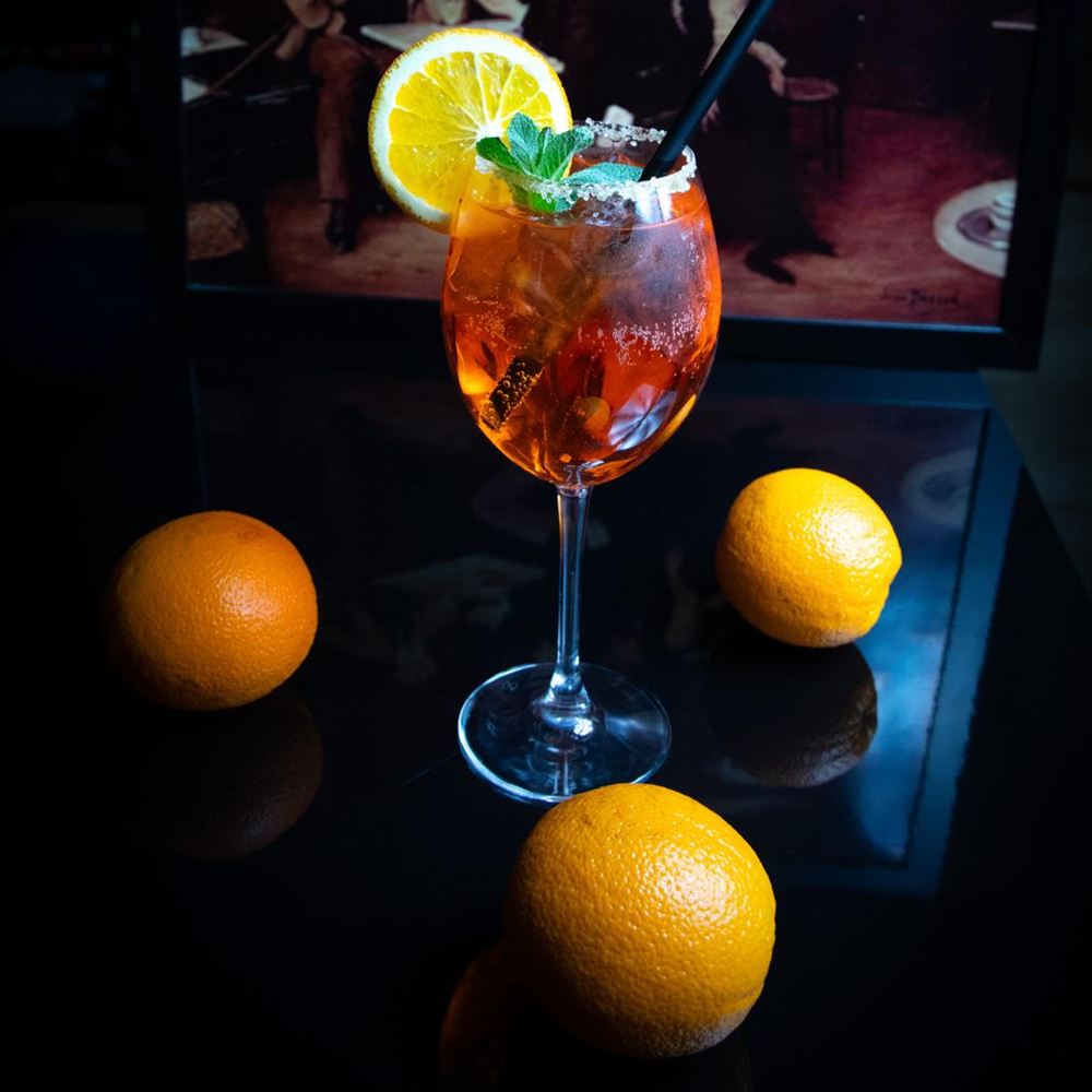 Aperol Spritz cu felie de portocală, pe masa barului